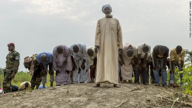 People pray as they bury 16 coffins in a Muslim cemetery in Bangui on December 11.