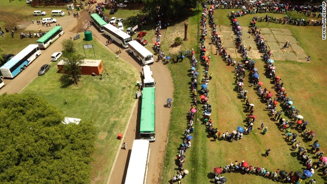 People queue to catch a bus to see the remains of Nelson Mandela at the Union Buildings on December 12. 