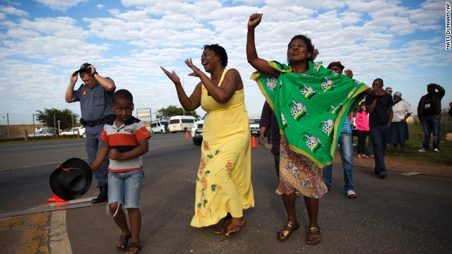 Women sing and dance after the hearse arrived at Waterkloof air base.