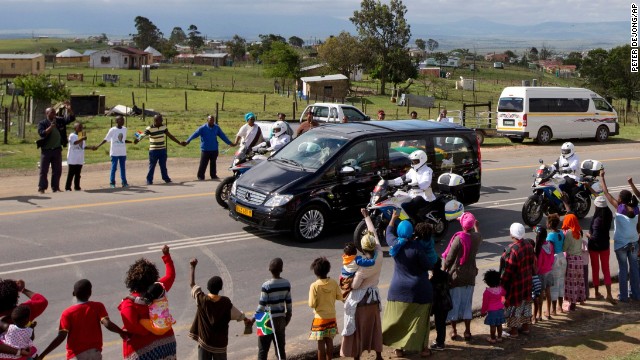 People hold hands as Mandela's hearse proceeds to his hometown and burial site. Mandela became South Africa's first black president in 1994. He had spent 27 years in jail for his activism against apartheid in a racially divided South Africa. 