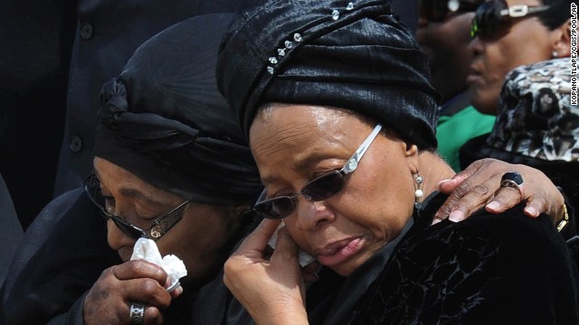 Nelson Mandela's widow Graca Machel, right, and Winnie Madikizela-Mandela, his former wife, wipe their tears as the former president's casket arrives at Mthatha Airport on December 14. 