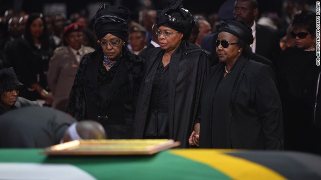 Mandela's ex-wife Winnie Madikizela Mandela, left, and his widow Graca Machel, center, stand by Mandela's casket during his funeral ceremony in Qunu on December 15.