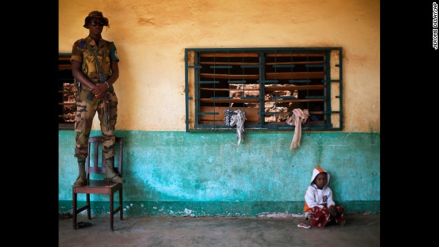 An African Union peacekeeper stands on a chair as a small child sits of the floor at an Islamic center where Peul refugees have sought protection in Bangui, Central African Republic, on Wednesday, December 18. France recently began a peacekeeping operation in the African nation, which has been dealing with violence between Muslim and Christian militias since a March coup.