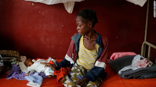 A severely malnourished child lays by his mother at a pediatric center in Bangui on Tuesday, December 17.