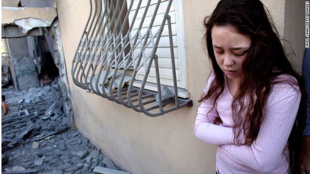 An Israeli girl stands outside her house after it was hit by a rocket fired from Gaza in November last year in Beersheba, Israel. 