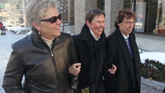 Plaintiffs Laurie Wood, left, and Kody Partridge, center, walk with attorney Peggy Tomsic on Wednesday, December 4, after a judge heard arguments challenging Utah's same-sex marriage ban.