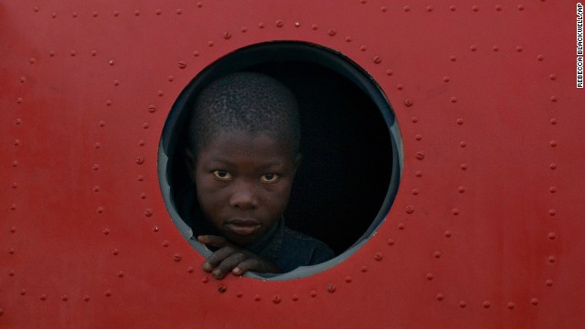 A boy looks out the broken window of a plane being used as shelter at M'Poko Airport in Bangui on December 21.