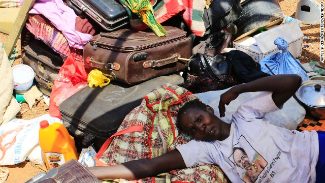 A mother displaced by recent fighting in South Sudan rests on top of her belongings inside a makeshift shelter at the United Nations Mission in Sudan on Monday, December 23. Clashes between rival groups of soldiers in the capital of Juba a week ago have spread across the country. 