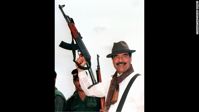Then-Iraqi President Saddam Hussein brandishes an AK-47 during his visit to villages in northern Iraq in 1998, in this Iraqi News Agency released photograph.
