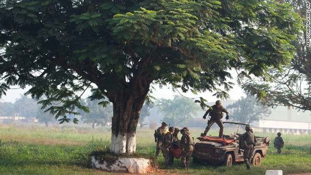 French soldiers load a wounded man onto the front of a military vehicle to get medical help in Bangui on December 23.