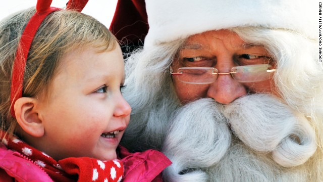 A man dressed as Santa Claus from Lapland, Finland, listens to a girl's Christmas wish on stage at a Christmas event organized by the Finnish Embassy in Seoul, South Korea, on Monday, December 23.