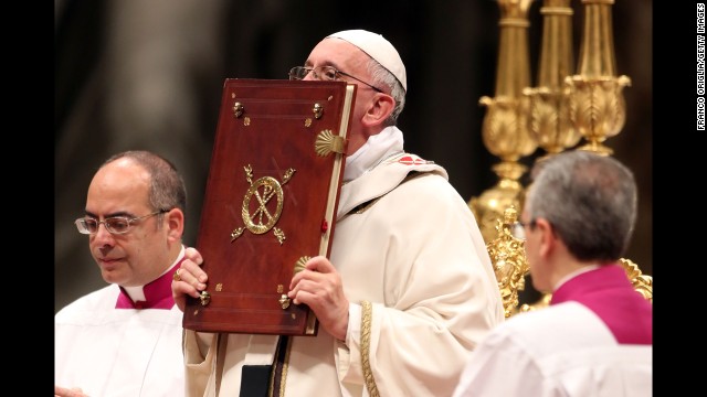 The Pope kisses the book of the Gospels. "God is light and in him there is no darkness at all," the Pope said.