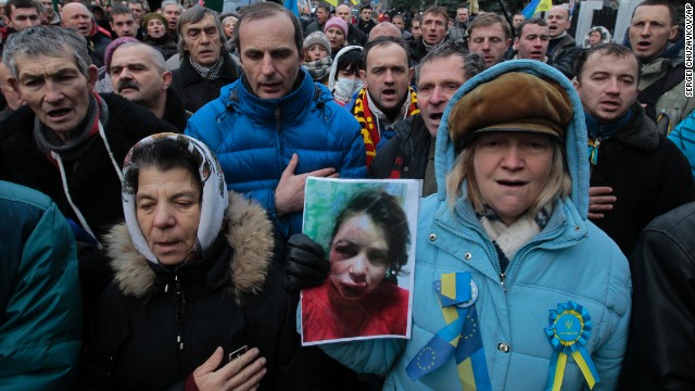 Activists outside the Ukrainian Interior Ministry in Kiev, hold a photo showing the injuries to journalist Tetiana Chornovol.