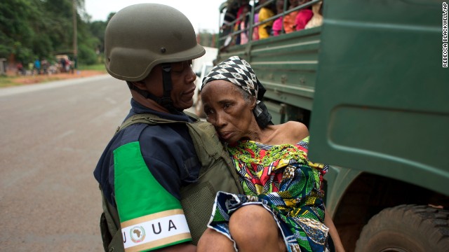 An African Union peacekeeper carries an elderly Cameroonian woman to a military vehicle shuttling citizens to the airport for an evacuation flight in Bangui on December 27. 