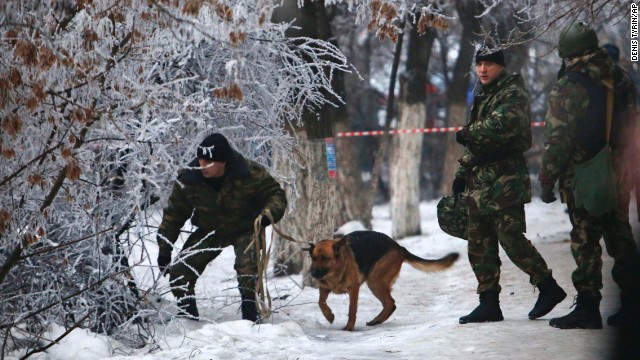 Police officers with a sniffing dog examine territory around the site of a trolleybus explosion in Volgograd, Russia on Monday December 30.