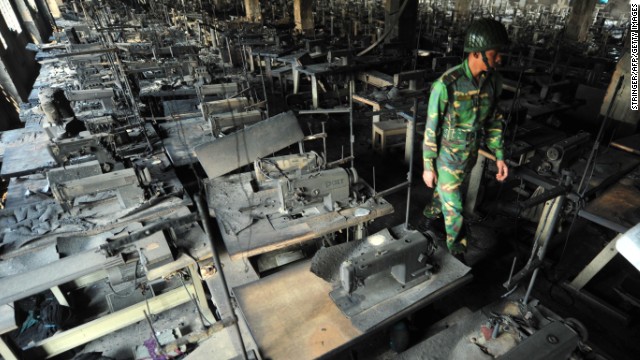 A Bangladeshi Army personel walks through rows of burnt sewing machines after a fire in the plant.