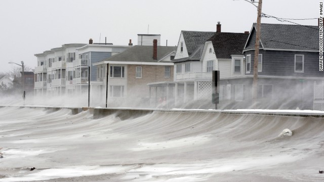 Winds whip snow from the beach across Winthrop Shore Drive in Winthrop, Massachusetts.