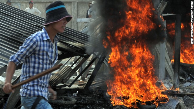 A man armed with a wooden stick rallies during a protest in front of a garment factory in Phnom Penh on January 3.