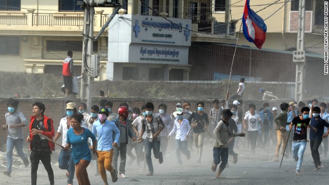 Cambodian protesters run from clashes with military police in Phnom Penh on January 3, after a week-long demonstration for better pay turned violent. 