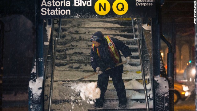 A worker clears snow from a subway station in Queens, New York, on January 3. Public schools were closed Friday after up to 7 inches of snow fell in New York City.