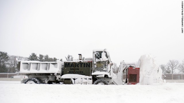 A truck-mounted snowblower clears a section of road in Dedham, Massachusetts, on January 3.