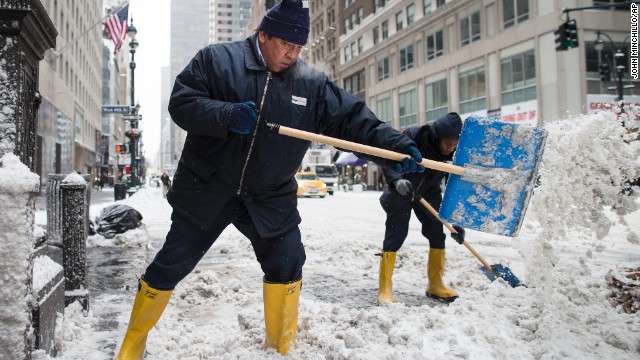 Workers clear snow off sidewalks on New York City's Fifth Avenue on January 3.