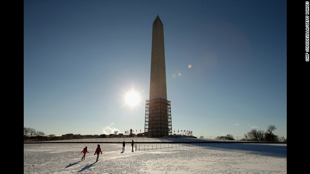 Tourists play in the snow at the base of the Washington Monument on January 3.