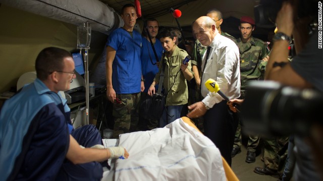 French Defense Minister Jean-Yves Le Drian, center right, speaks to a wounded soldier in a medical tent during a visit to the M'Poko Camp in Bangui on Thursday, January 2. France has sent 1,600 troops under United Nations mandate into Central African Republic to assist African troops.