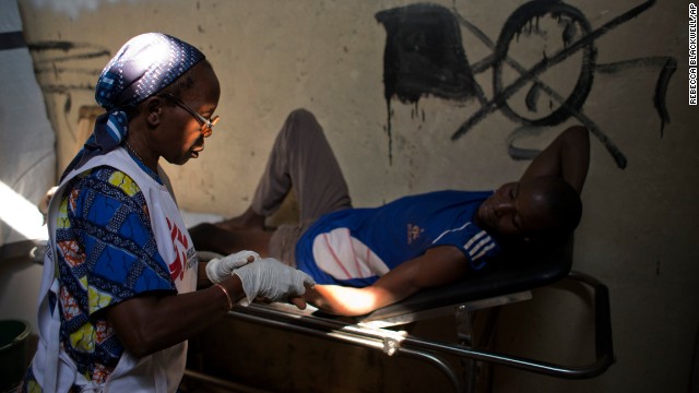 A medical worker checks the injuries of a man who has been struck by gunfire. The man was treated at a Doctors Without Borders clinic inside a makeshift camp in Bangui on January 2.