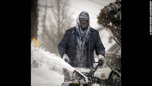 Snow clings to the clothing and facial hair of Jerome Williams as he uses a snowblower in front of his home in Roosevelt, New York, on January 3.