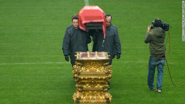 The coffin bearers place Eusebio's body down on a gold stand on the halfway line. The funeral takes place later Monday.