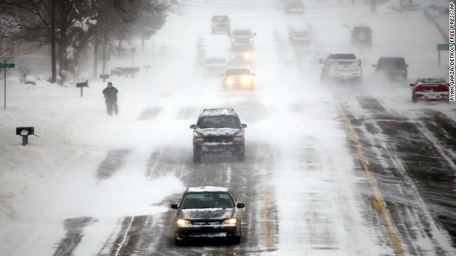 Vehicles drive down a snow-covered road in Burton, Michigan, on January 6.