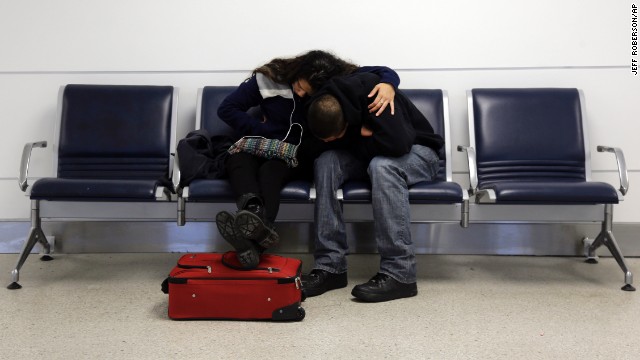 A man and woman do their best to get comfortable while stranded at Lambert-St. Louis International Airport on Sunday, January 5.