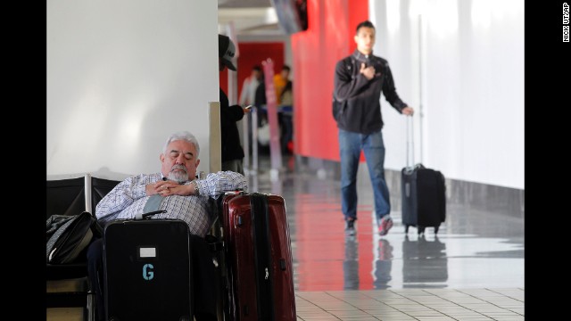 A passenger takes a nap inside Los Angeles International Airport on Friday, January 3, after his flight was canceled because of the weather on the East Coast.