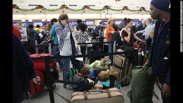 Travelers wait in line January 3 at Chicago Midway International Airport.