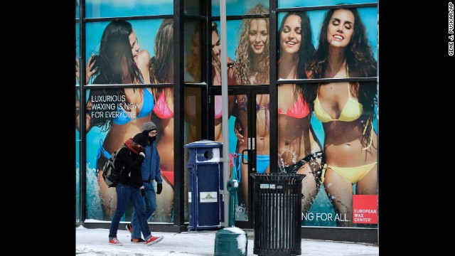 A couple walks past an advertisement in Pittsburgh during sub-zero temperatures January 7.