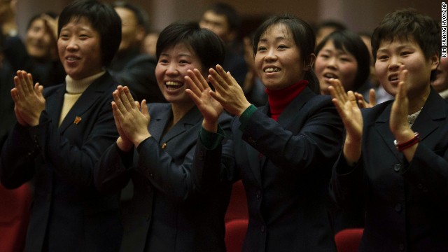 North Koreans applaud at the start of the game.