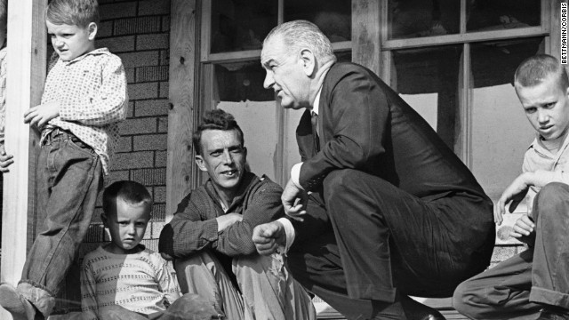 U.S. President Lyndon B. Johnson visits a family in Inez, Kentucky, during a tour of poverty-stricken areas of the country in April 1964. Earlier that year, Johnson declared a "war on poverty" in his State of the Union address. He then worked with Congress to pass more than 200 pieces of legislation, which included early education programs and social safety nets such as Medicare and Medicaid.