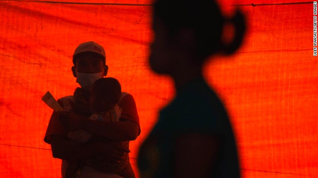 A man holds his son at a temporary evacuation center.