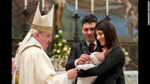 The Pope blesses a baby during the baptism ceremony.