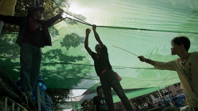 Thai anti-government protesters set up a spot with shade on a street outside the Government house in Bangkok on January 12, 2014.