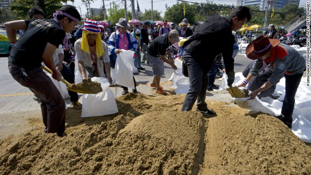 Anti-government protesters fill sandbags as they make barricades during a Bangkok rally on January 13, 2014. 