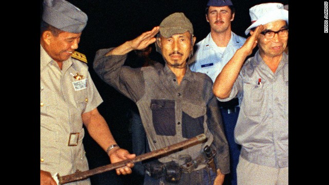 <a href='http://www.cnn.com/2014/01/17/world/asia/japan-philippines-ww2-soldier-dies/index.html'>Hiroo Onoda</a>, center, salutes after handing over his military sword on Lubang Island in the Philippines in March 1974. Onoda, a former intelligence officer in the Japanese army, had remained on the island for nearly 30 years, refusing to believe his country had surrendered in World War II. He died at a Tokyo hospital on January 16. He was 91.