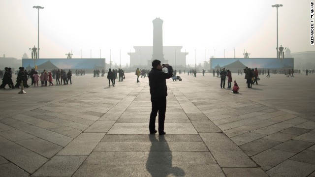 A tourist takes photos during a heavily polluted day in the capital's Tiananmen Square on January 16.