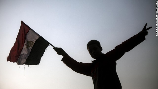 An Egyptian youth holds up his national flag outside a polling station in Cairo on January 14, day one of a two-day vote on a new constitution. 