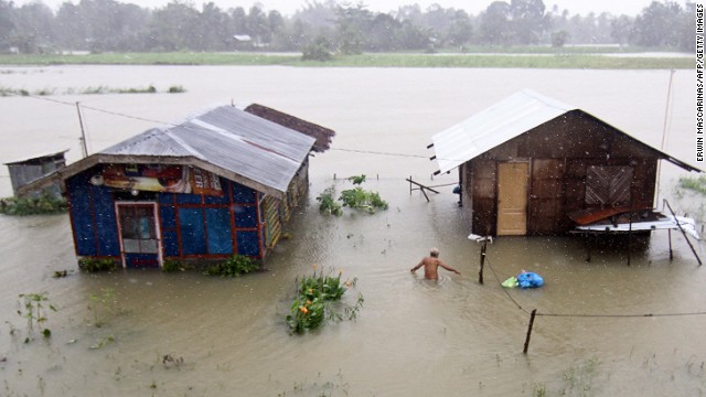 A resident of Butuan City on the southern Philippine island of Mindanao wades through floodwaters.