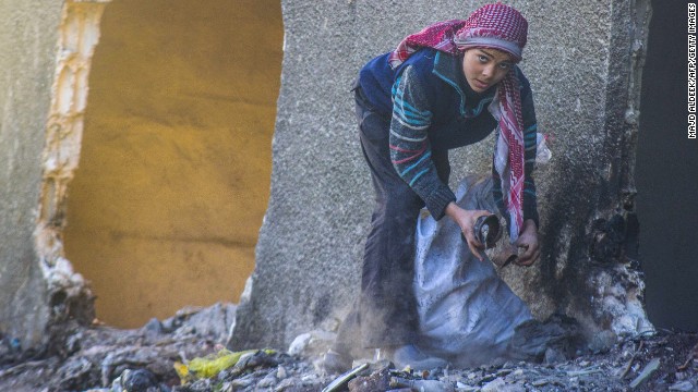 A Syrian child collects items from a garbage pile on Saturday, January 18, in Douma, northeast of the capital.