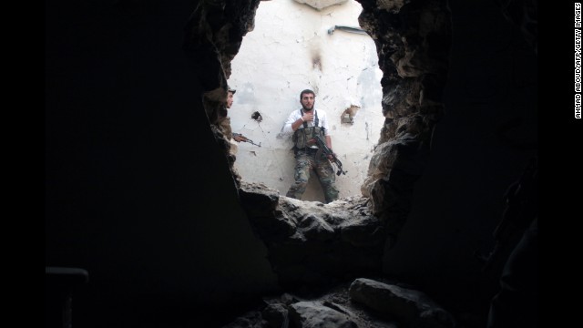 A rebel fighter holds his position in a damaged building during clashes with government forces in Deir Ezzor on Monday, November 11.