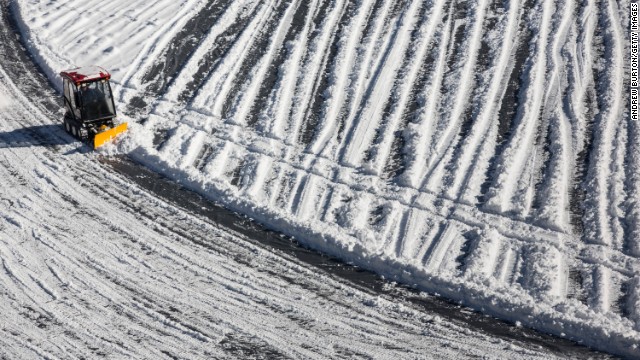 A crew member works to remove snow from the field. Super Bowl XLVIII will be the first Super Bowl held outdoors in a cold-weather city.