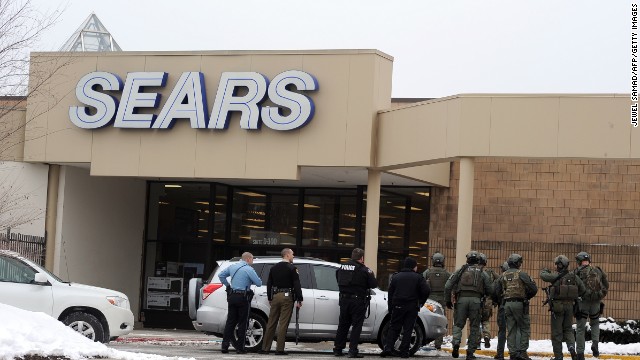 Police patrol outside a Sears store at the mall. 